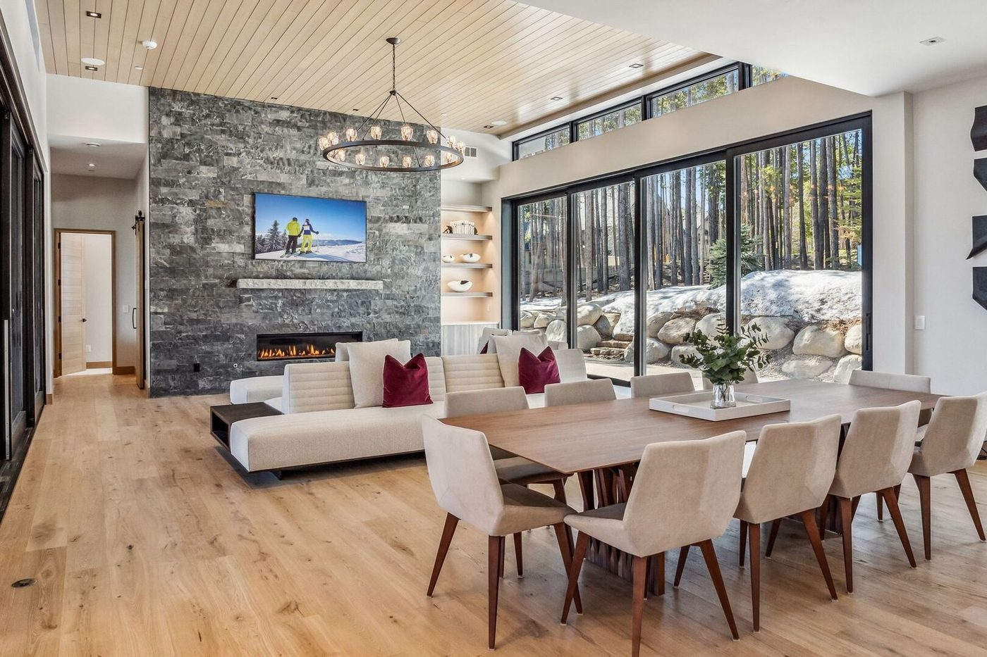 Auria great room with floor-to-ceiling windows, stone fireplace and dining for twelve